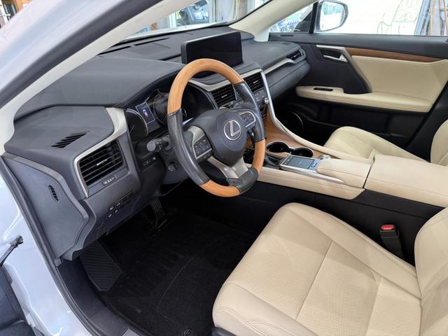 Lexus RX interior after a deep clean, showing cream leather seats, a wood-trim steering wheel, and a spotless dashboard